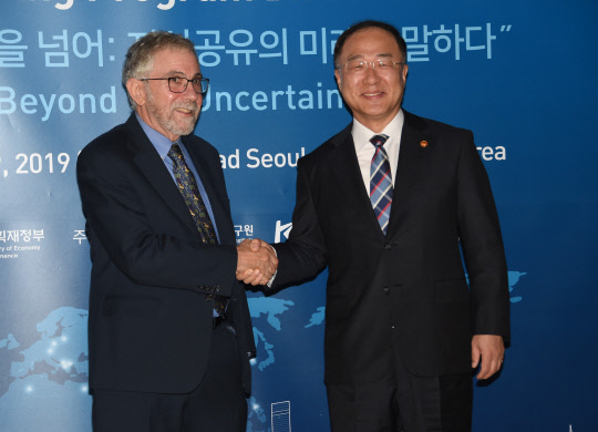 홍남기 부총리 겸 기획재정부 장관(사진 오른쪽)과 폴 크루그먼 교수가 악수하며 기념사진을 찍고 있다.(사진=기획재정부)